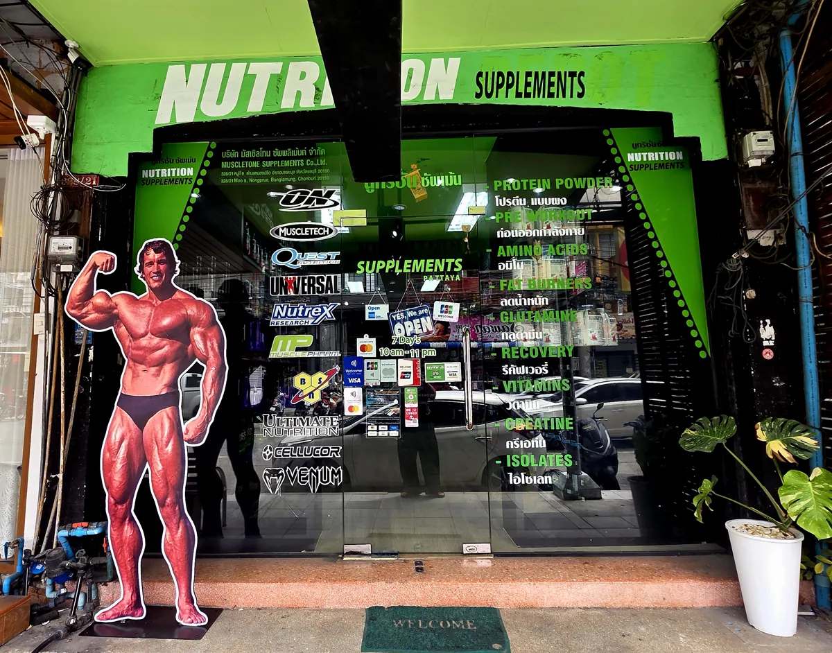 The Nutrition Supplements Pattaya shopfront on Second Road — bright green NUTRITION SUPPLEMENTS sign and bodybuilder cutout